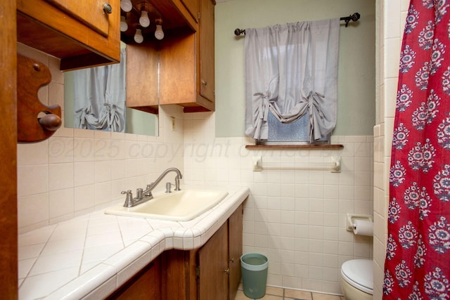 1626 N Apache St, Amarillo, TX 79107 - full bathroom with toilet, vanity, tile walls, a wainscoted wall, and tile patterned floors