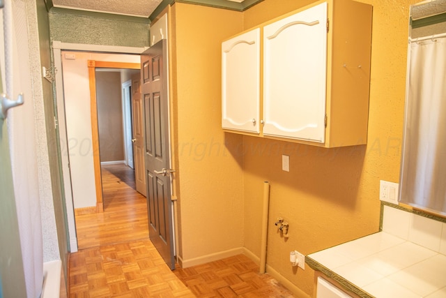 laundry area featuring light parquet floors