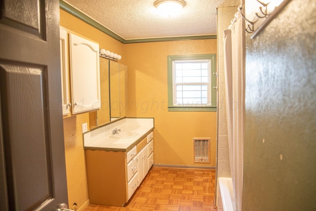 bathroom featuring vanity, a textured ceiling, and parquet flooring