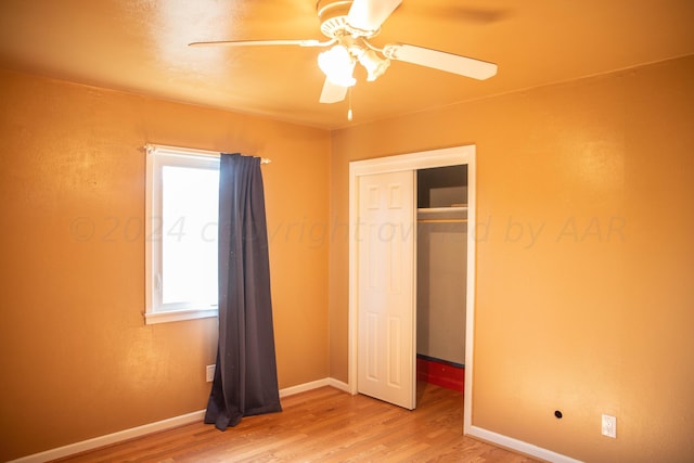 unfurnished bedroom with wood-type flooring, a closet, and ceiling fan