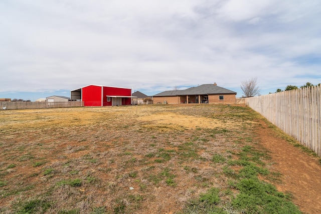 view of yard featuring an outbuilding, an outdoor structure, and fence