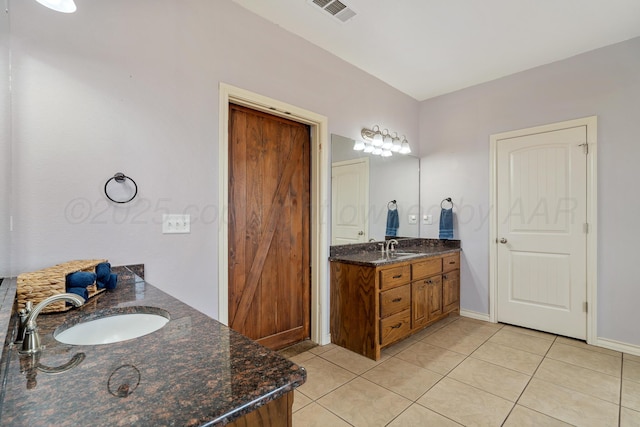 bathroom featuring tile patterned flooring, visible vents, two vanities, and a sink