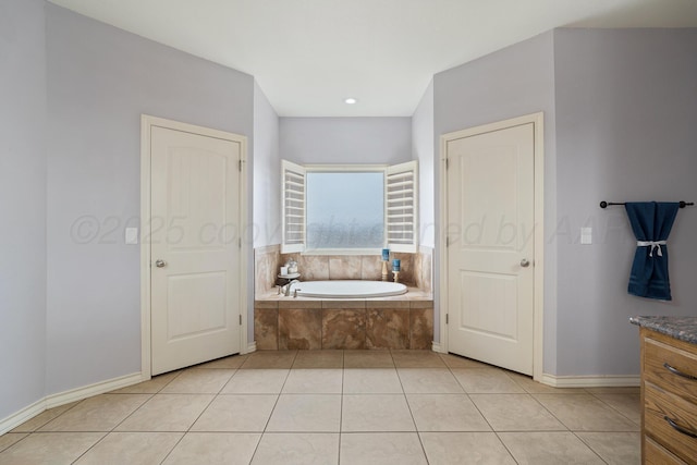 full bath with vanity, tile patterned floors, a garden tub, and baseboards