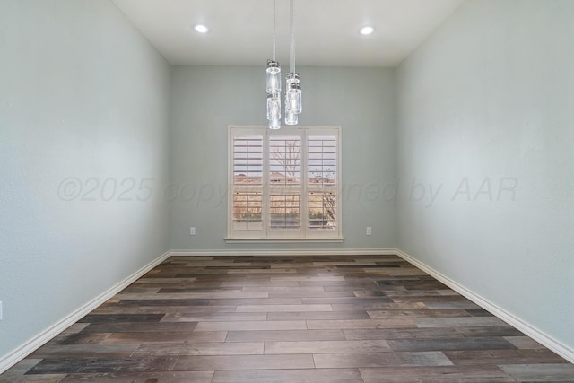 spare room with recessed lighting, dark wood-style flooring, a chandelier, and baseboards