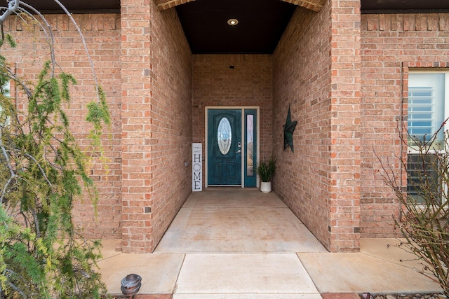 view of exterior entry with brick siding