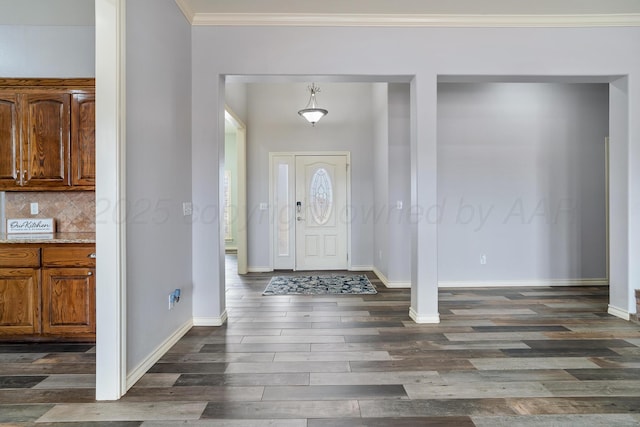 foyer entrance with dark wood finished floors, baseboards, and ornamental molding