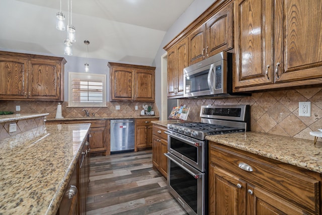 kitchen with light stone counters, stainless steel appliances, decorative backsplash, vaulted ceiling, and dark wood-type flooring