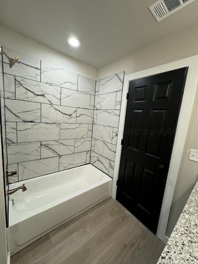 bathroom featuring tiled shower / bath and hardwood / wood-style floors