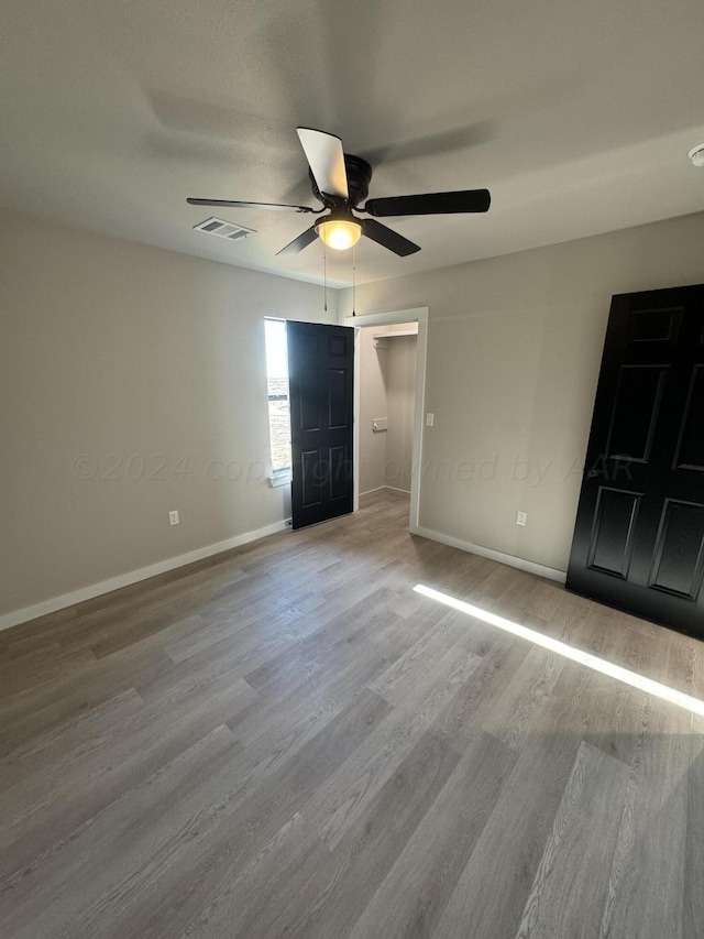 unfurnished bedroom with light wood-type flooring and ceiling fan