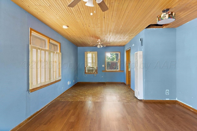 spare room with a ceiling fan, wood ceiling, wood finished floors, baseboards, and a heating unit