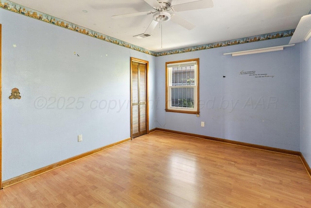 unfurnished room with ceiling fan, wood finished floors, and baseboards
