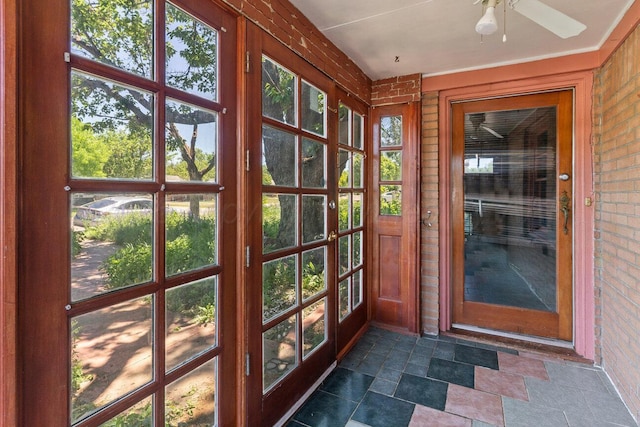 unfurnished sunroom with a ceiling fan and french doors