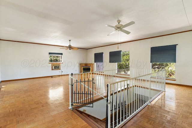 spare room featuring ceiling fan, baseboards, and crown molding