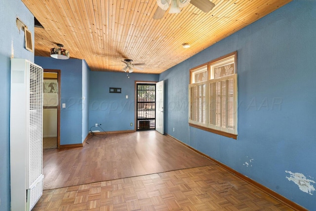 unfurnished room with ceiling fan, a heating unit, baseboards, and wooden ceiling