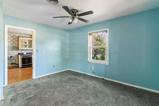 empty room with carpet flooring, baseboards, and ceiling fan