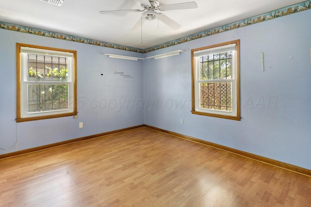 spare room with wood finished floors, baseboards, and ceiling fan