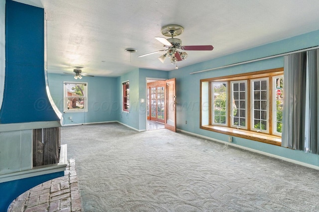 carpeted spare room with ceiling fan, baseboards, and healthy amount of natural light