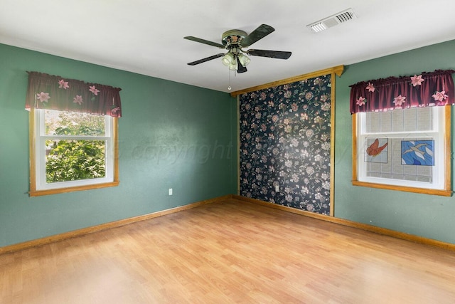 spare room with wood finished floors, ceiling fan, and baseboards