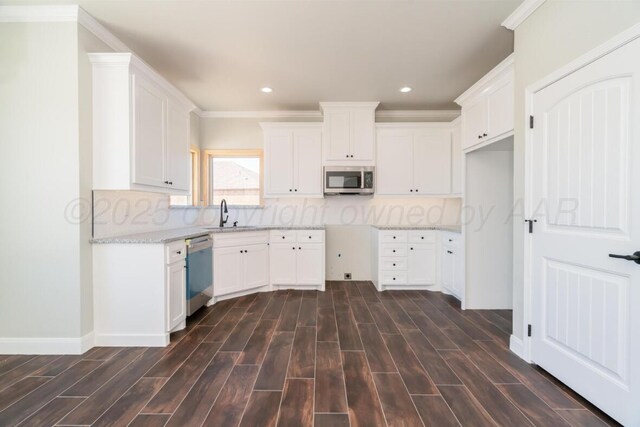 1634 Northridge St, Dumas, TX 79029 - kitchen with stainless steel appliances, a sink, dark wood finished floors, light stone countertops, and recessed lighting