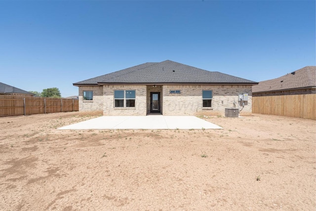 1634 Northridge St, Dumas, TX 79029 - back of property with a patio area, a fenced backyard, a shingled roof, and brick siding