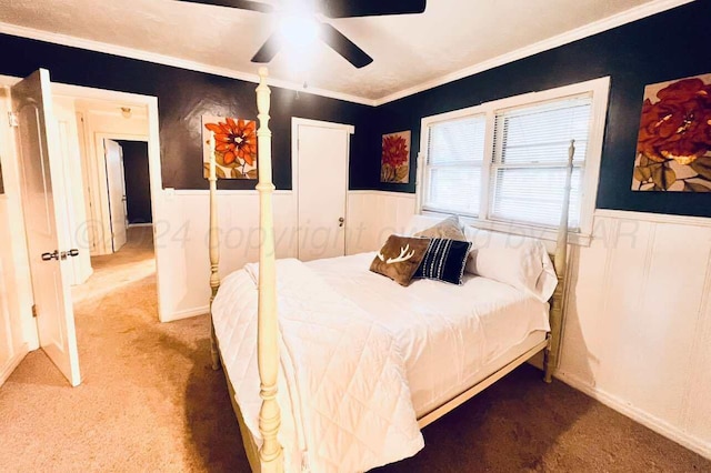 carpeted bedroom with ornamental molding and ceiling fan