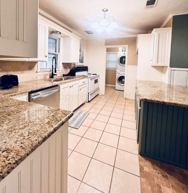 kitchen featuring light stone counters, stacked washing maching and dryer, crown molding, white electric range, and dishwasher