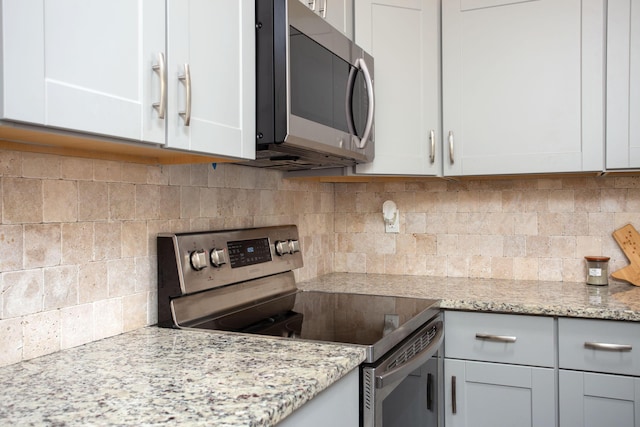 kitchen featuring appliances with stainless steel finishes, backsplash, and white cabinetry