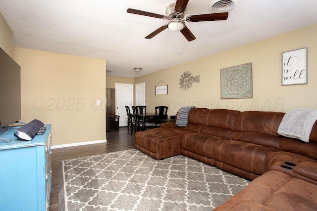 living room with wood finished floors, ceiling fan, and baseboards