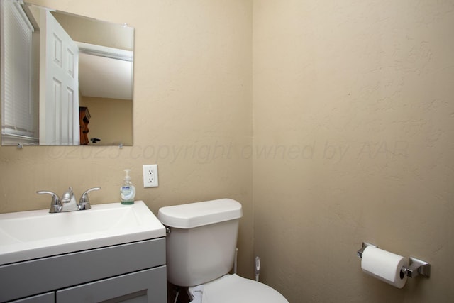 half bathroom with toilet and vanity
