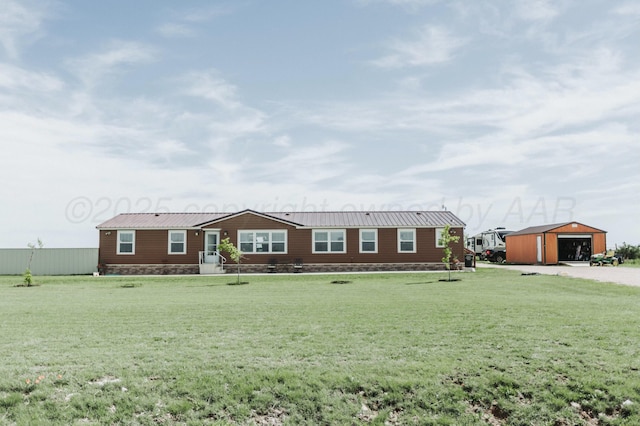 manufactured / mobile home featuring a detached garage, an outbuilding, a front lawn, and metal roof