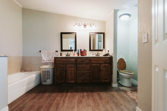 bathroom with a sink, a bath, ornamental molding, and wood finished floors