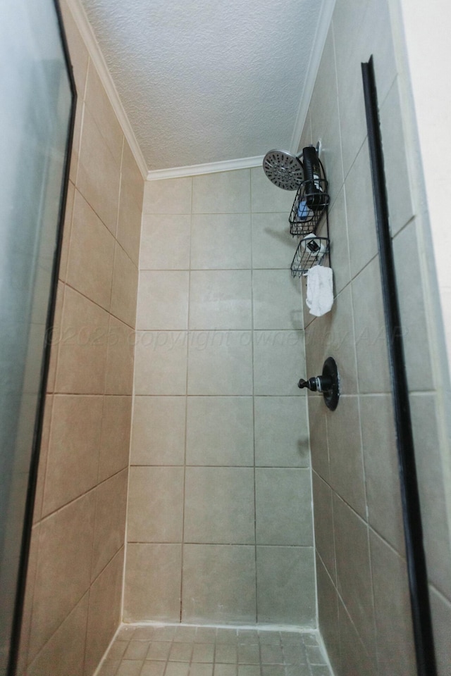 full bathroom with crown molding, a textured ceiling, and a tile shower