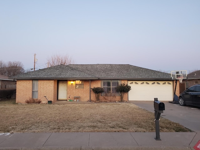 single story home with brick siding, a front yard, roof with shingles, a garage, and driveway