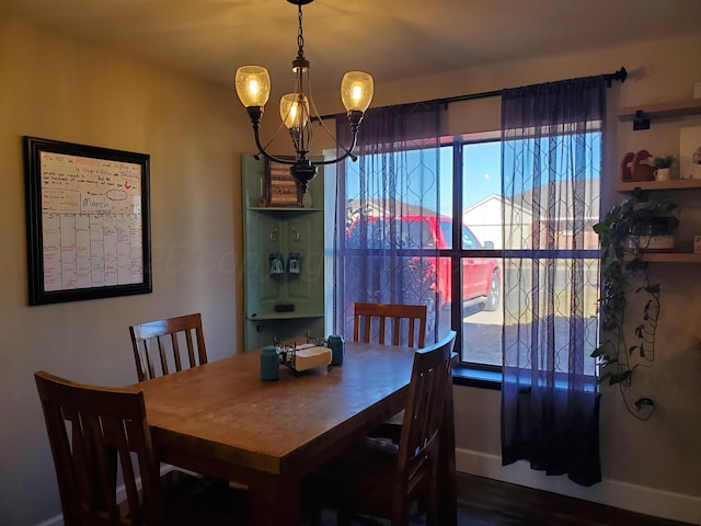 dining space with plenty of natural light, baseboards, and an inviting chandelier