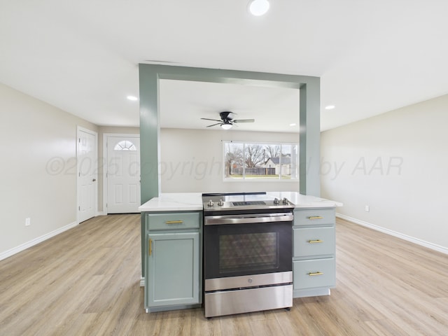 kitchen with light countertops, light wood-style flooring, baseboards, stainless steel electric stove, and a ceiling fan