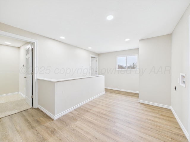spare room featuring light wood finished floors, baseboards, and recessed lighting