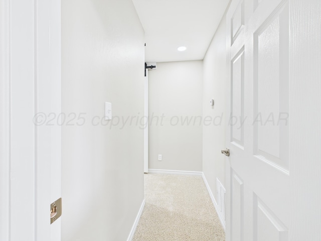 hallway featuring carpet flooring, baseboards, and visible vents