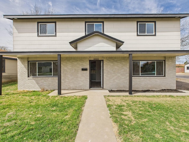 view of front of home with brick siding and a front lawn