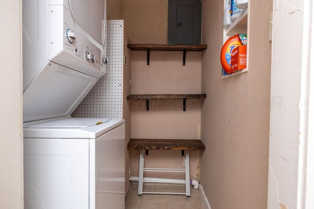 washroom with laundry area, stacked washer / dryer, baseboards, electric panel, and light tile patterned floors