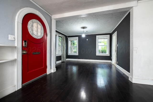 entryway with crown molding, a textured ceiling, baseboards, and wood finished floors
