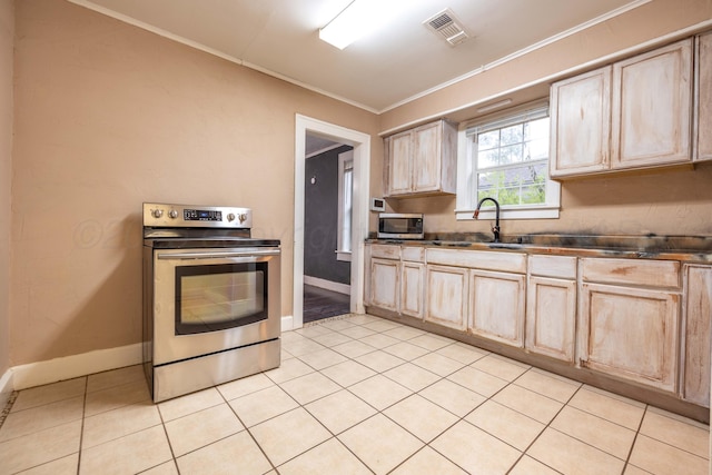 kitchen with appliances with stainless steel finishes, ornamental molding, a sink, and light brown cabinets