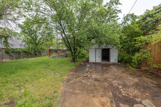 view of yard with a storage shed, an outdoor structure, and a fenced backyard