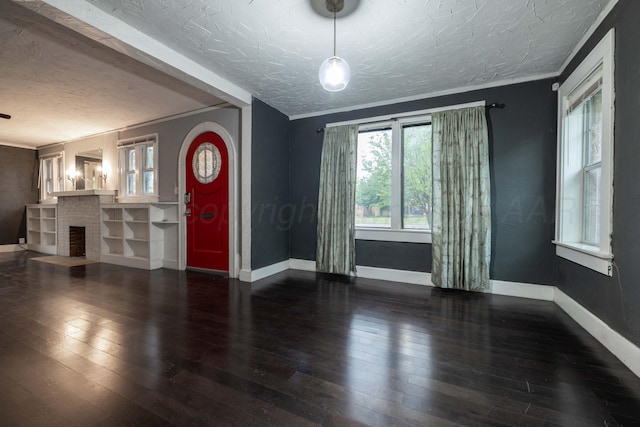 foyer featuring baseboards, a textured ceiling, and hardwood / wood-style floors