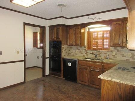 kitchen featuring crown molding, decorative backsplash, a sink, and black appliances