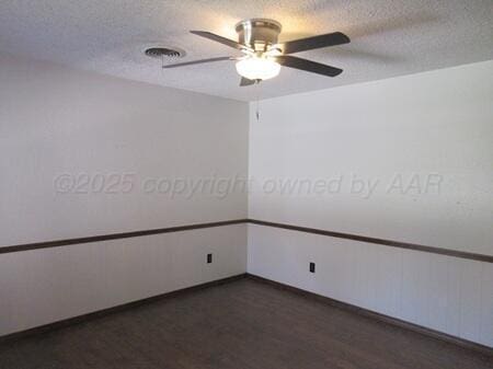unfurnished room featuring visible vents, a textured ceiling, wood finished floors, and ceiling fan
