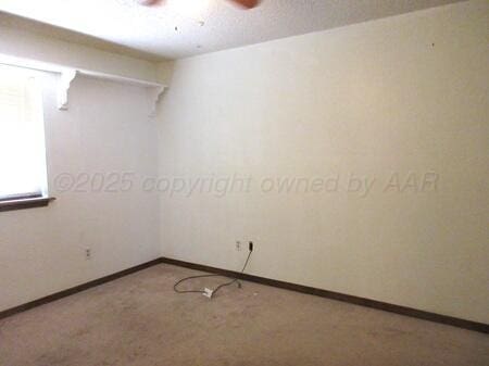 spare room featuring baseboards and a ceiling fan