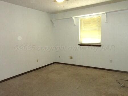 carpeted empty room featuring baseboards