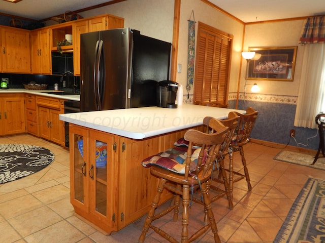 kitchen with freestanding refrigerator, light countertops, dishwasher, a sink, and crown molding
