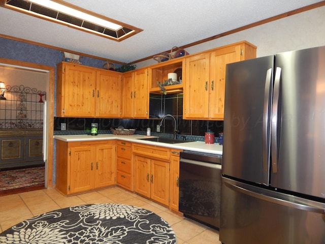kitchen featuring a sink, black dishwasher, light tile patterned floors, light countertops, and freestanding refrigerator