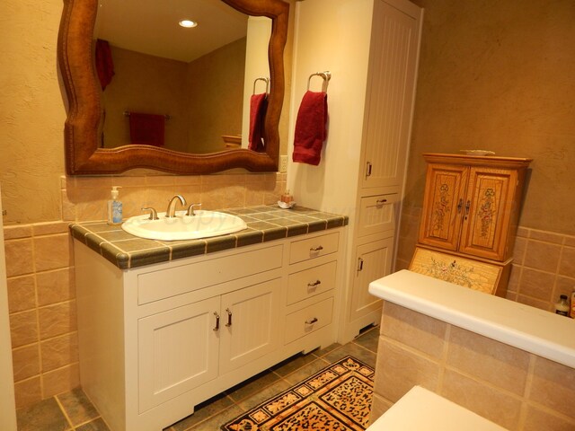 bathroom featuring vanity, tile patterned flooring, and tile walls